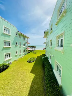 a yard between two buildings with the ocean in the background at Victorian Condominio in Cabarete