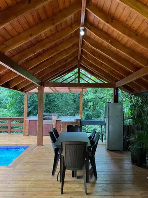 a patio with a table and chairs under a wooden roof at Villa Reina in Buena Vista