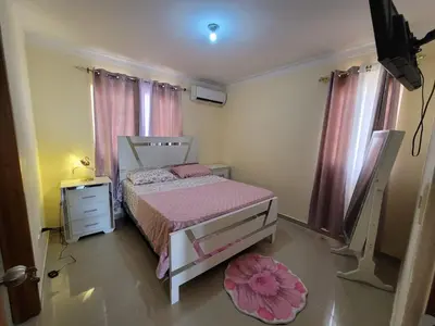 a bedroom with a bed and a dresser and curtains at Elegante apartamento en San isidro in Mendoza