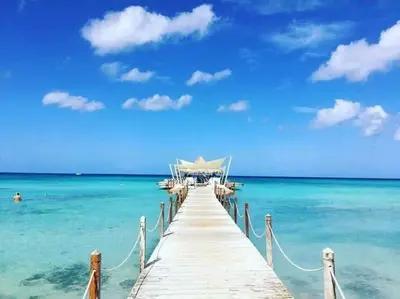 a dock in the ocean with boats in the water at Cadaques Caribe Bayahibe Private beach in Bayahibe