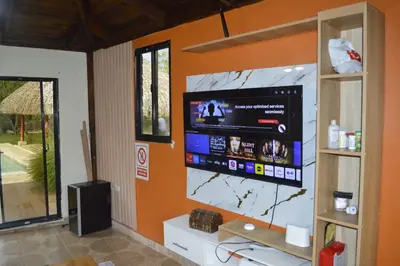 a living room with a flat screen tv on a wall at Villa Doña Plinia in El Cruce