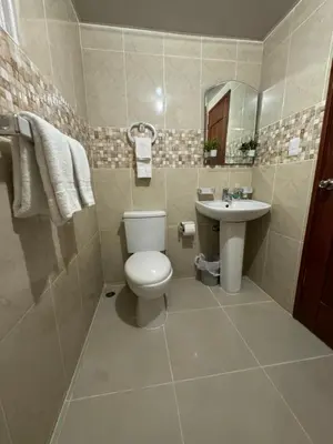 a bathroom with a toilet and a sink at Casa las América in La Cana