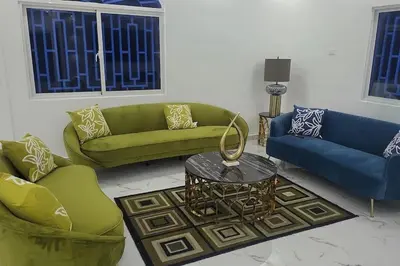 a living room with two green couches and a table at Bocachica house,apts,village in Jubey