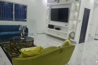 a living room with a green chair and a tv at Bocachica house,apts,village in Jubey