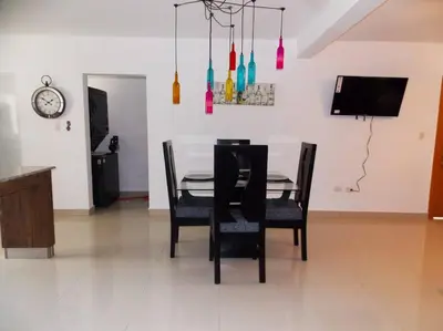 a dining room with a table and chairs and a clock at Cañaveral Del Mar 1 Quiet and extremally relaxing! in San Felipe de Puerto Plata