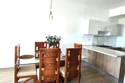 a kitchen with a table and some chairs and a counter at New 2 BR apt with swimming pool at playa bonita in Las Terrenas