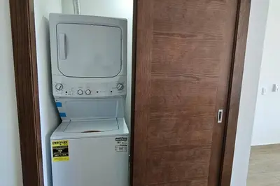 a computer on top of a refrigerator next to a door at New 2 BR apt with swimming pool at playa bonita in Las Terrenas