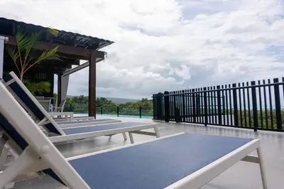 a patio with chairs and a table and a fence at New 2 BR apt with swimming pool at playa bonita in Las Terrenas