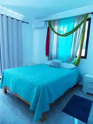 a bedroom with a blue bed with a window at Residencial Victoria in Sampiño