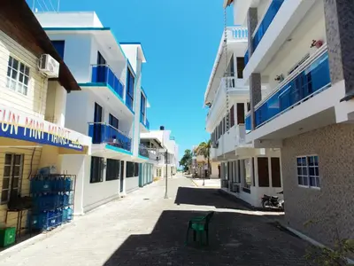 a green chair sitting in the middle of a street at Residencial Victoria in Sampiño