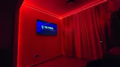 a room with red lights and a tv on a wall at comodidad y tranquilidad in Mendoza