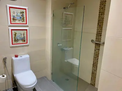 a bathroom with a toilet and a glass shower at Blue View Beachfront Apartment with Ocean View in Sampiño