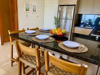 a kitchen with a table with a bowl of fruit at Blue View Beachfront Apartment with Ocean View in Sampiño