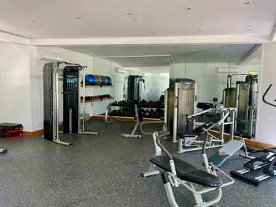 a gym with several tread machines and a mirror at Blue View Beachfront Apartment with Ocean View in Sampiño