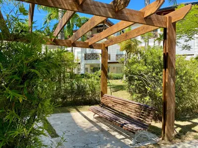 a wooden bench sitting under a wooden pergola at Blue View Beachfront Apartment with Ocean View in Sampiño