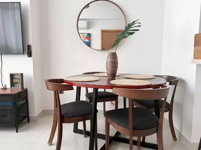 a dining room table with chairs and a mirror at Modern City Condo El Millon in El Jobo de Mendoza