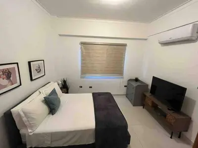 a bedroom with a bed and a flat screen tv at Modern City Condo El Millon in El Jobo de Mendoza
