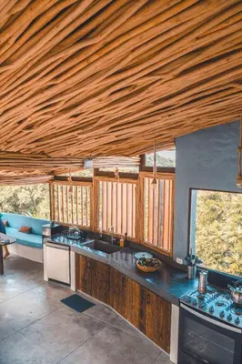 a kitchen with wooden ceilings and a counter top at BambooJam Villa in La Ceiba