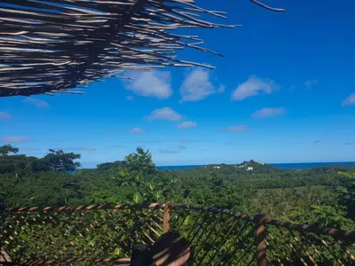 a view of the ocean from the porch of a house at BambooJam Villa in La Ceiba