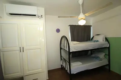 a small room with a bunk bed and a door at Altea Dive Inn, Bayahibe in Bayahibe