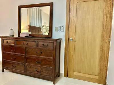 a dresser with a mirror next to a wooden door at Vista Panorama Cipres in Hato Mayor