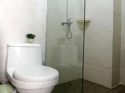 a bathroom with a toilet and a glass shower at Vista Panorama Cipres in Hato Mayor
