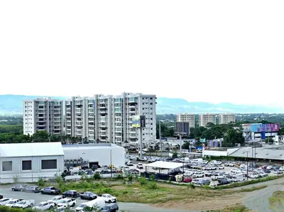 a parking lot with cars parked in front of a large building at Vista Panorama Cipres in Hato Mayor
