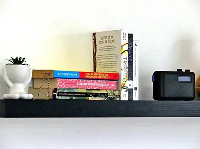 a stack of books sitting on a shelf with a tv at Vista Panorama Cipres in Hato Mayor
