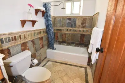a bathroom with a toilet and a bath tub at Bluefish Condo, Ocean Front, Sunrises, Pool, Hot Tub, Under New Management in Sosúa