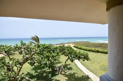 a view of the ocean from a building with a tree at Bluefish Condo, Ocean Front, Sunrises, Pool, Hot Tub, Under New Management in Sosúa
