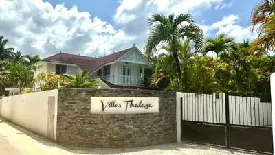 a house behind a fence with a gate with a villas holiday sign at Villa 4Bdrms 3.5baths with pool, Jacuzzi and Starlink WiFi in Las Terrenas