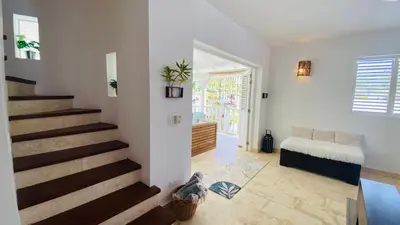 a living room with a staircase and a bed at Villa 4Bdrms 3.5baths with pool, Jacuzzi and Starlink WiFi in Las Terrenas