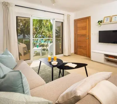 a living room with a couch and a table with drinks on it at Direct View and Access to Beach! in Eslabón