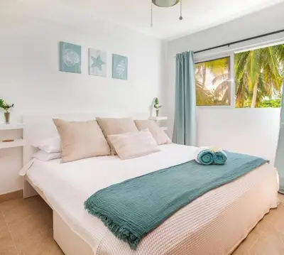 a bedroom with a large white bed with a window at Direct View and Access to Beach! in Eslabón