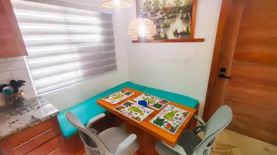 a small table with chairs and a table with paintings on it at Brisa Atlántico - Secluded Beach in La Piña