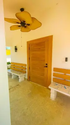 a room with a ceiling fan and a door and benches at Brisa Atlántico - Secluded Beach in La Piña