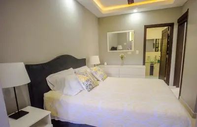 a bedroom with a large bed with pillows and a mirror at Beautifully updated in the heart of town in Cabarete