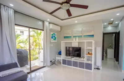 a living room with a ceiling fan and a tv at Beautifully updated in the heart of town in Cabarete