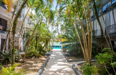 a walkway with palm trees in front of a building at Beautifully updated in the heart of town in Cabarete