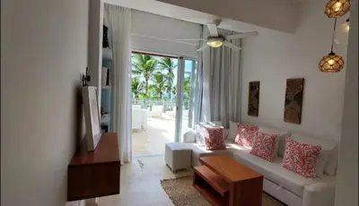 a living room with a white couch and a table at Luxury Penthouse Coson bay in Las Terrenas