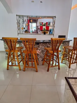 a bar with four wooden chairs and a counter at Casa Rural con Piscina in Azua de Compostela