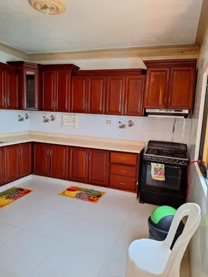 a kitchen with wooden cabinets and a stove at Casa Rural con Piscina in Azua de Compostela