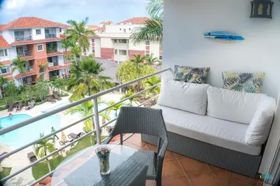 a balcony with a couch and a view of the pool at Ocean One Beach Condos Cabarete in Cabarete