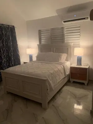 a bedroom with a white bed with two night stands at Romeos Place in Las Coles