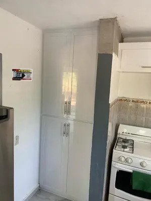 a kitchen with white cabinets and a stove at Romeos Place in Las Coles