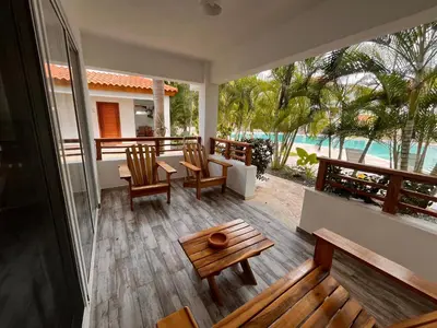 a porch with chairs and a table and a view of the water at Residencial Paraiso C102 in Bayahibe