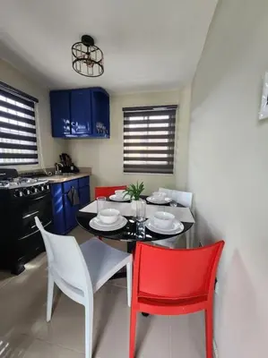 a kitchen with a table and red chairs in a room at Rooftop Apartment in Villa Francisca