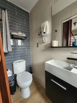 a bathroom with a white toilet and a sink at Rooftop Apartment in Villa Francisca