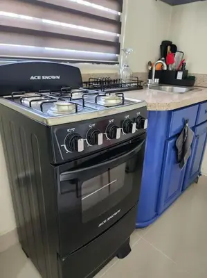 a kitchen with a black stove and a counter at Rooftop Apartment in Villa Francisca