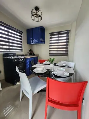 a kitchen with a table and a red chair at Rooftop Apartment in Villa Francisca